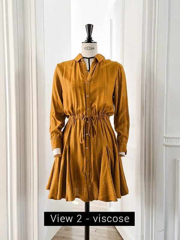 Stella dress shown here in view 2 in a light viscose. The fabric is ochre and the dress in photographed in a room full of light.
