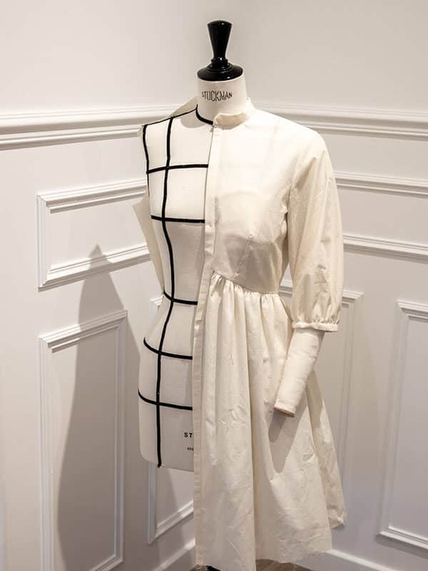 The French Poetry Pleiades 2 dress pattern is shown here as a toile (half dress, made of white calico, to showcase the lines of the pattern). It features a slightly puffed 3/4 length sleeve, and the bodice has a characteristic inverted v-cut. It has bust darts.